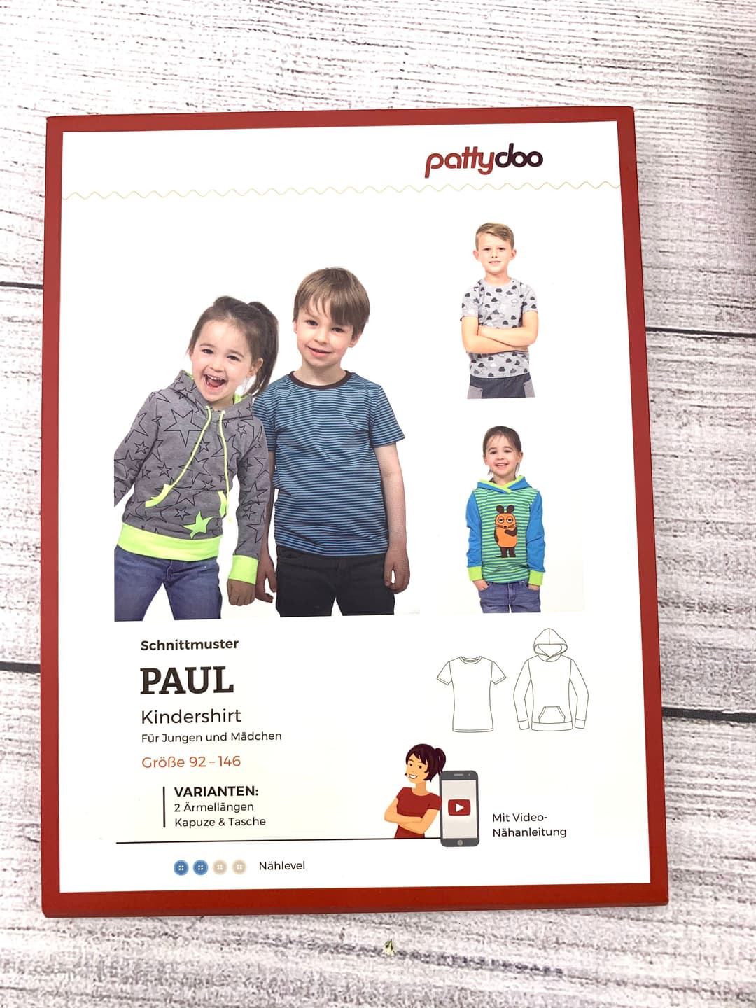 Wood table with porcelain mug, leather journal, brass pen, leather key ring, and a houseplant.